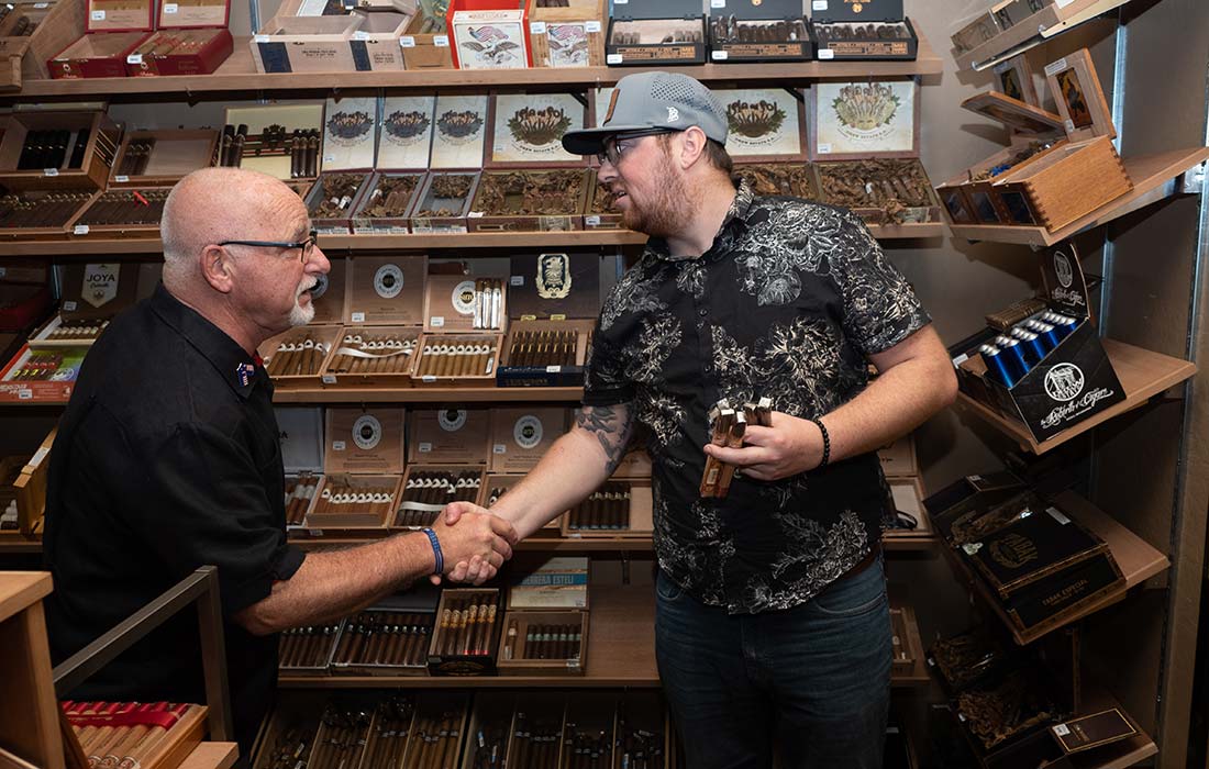 David shaking hands with a cigar customer in the walk in humidor
