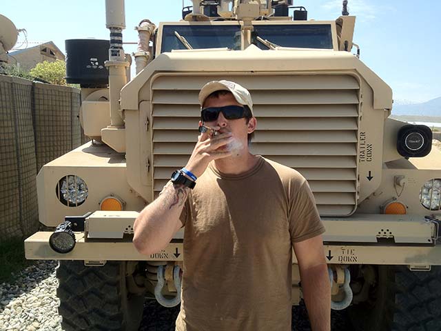 Military soldier smokes cigar downrange